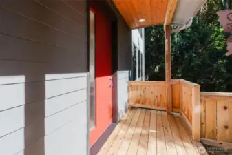 A vibrant red exterior door makes a bold statement, instantly drawing the eye and adding a pop of personality to the exterior facade. An obscure glass window runs almost the full length of the door, offering a sleek, modern touch while maintaining privacy and allowing soft, diffused light to filter inside.