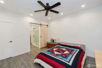 Barn doors lead to the private primary bath.