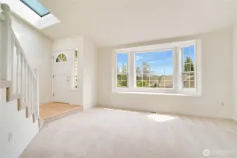 The formal living room features a grand bay window to bring in an abundance of natural light into the space. With the skylight above the front door, the sunshine really showcases the fresh paint and gleaming hardwood floors.