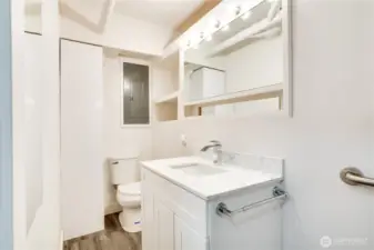 The three-quarter bath features an updated vanity, bright lighting, LVP flooring, and a large corner shower!