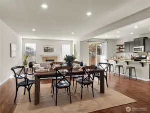 Open-concept design featuring a connected living, dining, and kitchen area with natural light throughout.