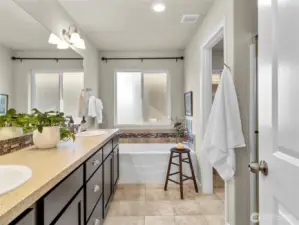 Private ensuite bathroom with dual vanities, soaking tub, and separate shower.