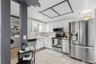The updated kitchen features a fresh approach with white painted cabinets, and stainless appliances. Imagine your version of portable kitchen island in the passage way, for extra counter space.