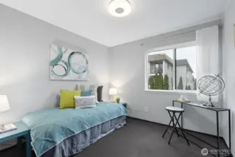 An ample size secondary bedroom has space for many uses. Shown here to accommodate a desk area, and pull out bed. Or use for a full home office. Not seen is the extra high, double door closet with chalkboard surface.