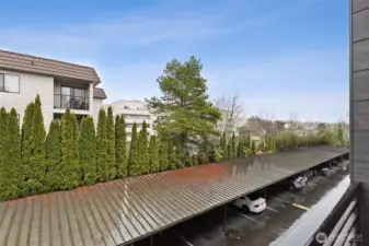 The view from the small balcony shows the view and position of the unit on the quieter, East/SE side of the building. A single, one-car garage with garage door is included with the unit.