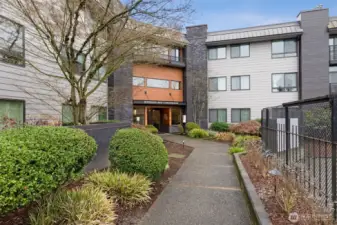 A pretty walk way between the entrance to NORTHGATE WEST, leads to the secure front door and lobby.  Photo shows the massive upgrade to the building in 2023 including new siding, windows, roof and more. All paid in full.