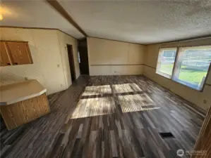 The family room with new flooring that extends throughout the kitchen, is large and comfortably located near the utility room and the 2nd and 3rd bedrooms.