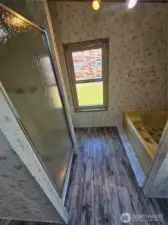 A separate enclosed shower is across from the large bathtub.