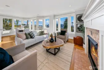A panorama of view windows span the south side of this house. Views of Elliott Bay, Space Needle, and Downtown Seattle. Cozy gas fireplace anchors the space.