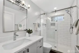 This primary bathroom features Hansgrohe fixtures and elevated tiling.