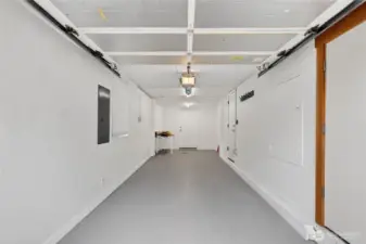 This long garage has a drain under the white table, so could be a perfect spot to add another bathroom.  The previous seller created a rendering for this.  This space sits off of the second bedroom on the main-level and may afford the opportunity to create a second primary suite on the main- buyer to verify.  There is also a large storage closet in the bottom of the right frame.