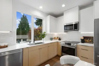 The large window frames the kitchen sink.