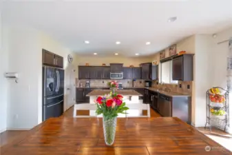 The connection between the kitchen, dining, and living room enhances the sense of space and comfort.