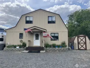 Front view of the house and storage shed. Lots of parking.