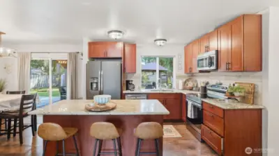 Slab granite countertops with large center island with breakfast bar and all stainless steel appliance package