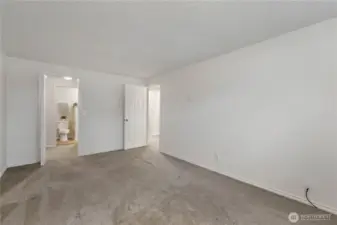 Another view of the primary suite looking out to the hallway and through the walk-in closet to the attached bath