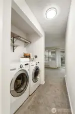 The laundry space has added shelving & the front-load washer & dryer are an added bonus