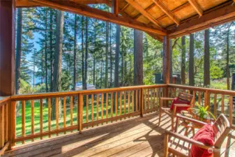 Level grass area scattered with native trees on south side of the yard. Covered deck offers outdoor space year-round.