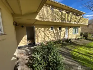 Entrance faces South, yard grass space to right with deciduous trees
