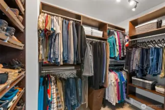 Generous primary walk-in closet featuring a custom closet system for efficient storage and organization.