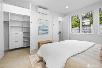 A custom walk-in closet keeps wardrobes neatly organized, while soft morning light filters through bedroom windows framing the terraced hillside. Photos are of model home 2009B.