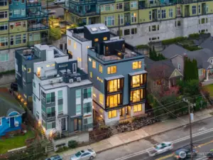 Mid-range aerial highlights the community’s pocket scale—only four homes, each with its own rooftop deck and street presence. Photos are of model home 2009B.