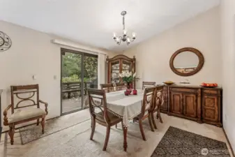 Formal dining looks out to wooded wonderland, fenced yard and garden.