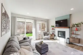 Open living area with gas fireplace, custom mantel, and large sliding door leading to the covered patio and backyard.