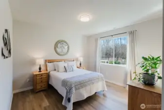 Comfortable primary suite filled with natural light and peaceful views overlooking the greenbelt.