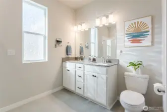 Well-appointed en-suite with dual sinks, quartz surfaces, and modern lighting.