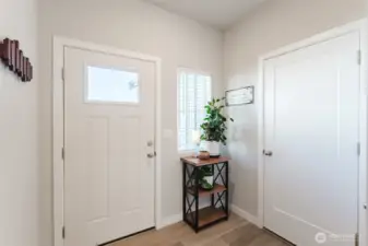 Welcoming entry with natural light, clean lines, door into the garage and convenient closet storage nearby (not pictured).
