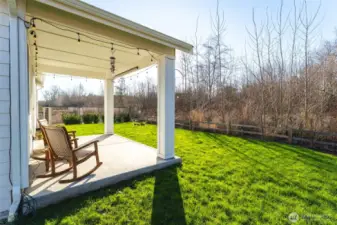 Covered patio with peaceful greenbelt views, creating a comfortable outdoor seating area.