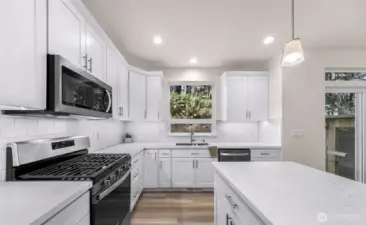 Kitchen with island seating, stainless appliances, and ample cabinet storage.