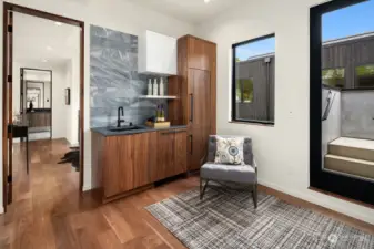 The landing area leading to generous roof deck offers a gracious mini-kitchen to keep chilled beverages at the ready. Note the peek into extended guest suite to the left, offers a lovely sitting area beyond the sleeping quarters.