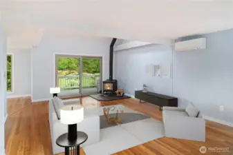 Another view of the living room facing west, with the covered deck in the background. The cozy wood stove was just inspected and it heats the whole condo. A newer mini-ductless both heats and cools the room. Lovely!