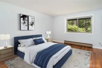 The spacious primary bedroom has a newer window overlooking the woods and golf course.