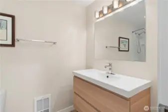 The updated full hallway bathroom has the same cabinetry and fixtures as the primary bedroom bath has, creating a sense of spaciousness and harmony.