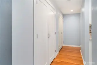 The hallway doors house the washer & dryer, the hot water heater, and lots of closet space. The kitchen is to the right.  Down the hall is where the private, primary bedroom is located.