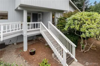 The condo offers two entrances, the easy, breezeway entrance on the left with just one step, and the stairway entrance on the right which leads to the additional guest parking spaces.