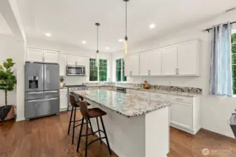 Gorgeous granite countertops, large center island, energy efficient stainless steel appliances, breakfast bar, sleek white cabinetry, tons of storage.