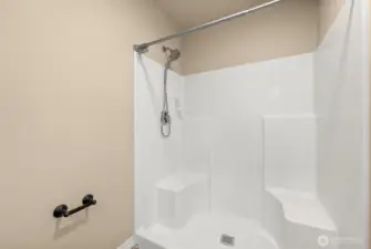 Primary suite shower and toilet area.