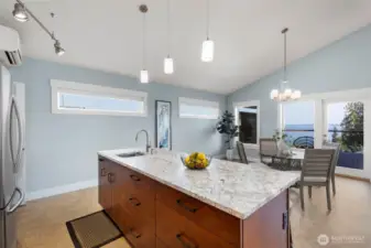 Large center island with prep sink, pendant lighting, and seating, designed for both cooking and gathering.