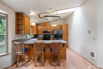 Kitchen offers bar seating, a pot rack and a skylight.