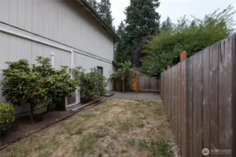 The side yard is fenced separately from the back yard. There is a man door in the gate that leads to the front driveway. The man door into the garage is also here.