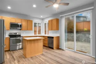 Kitchen with stainless steel appliances, LVP flooring, and backyard access