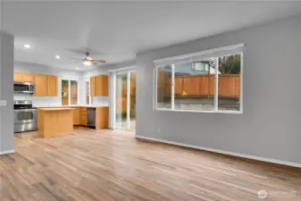 Family room with gas fireplace and LVP flooring opens to kitchen and eating area