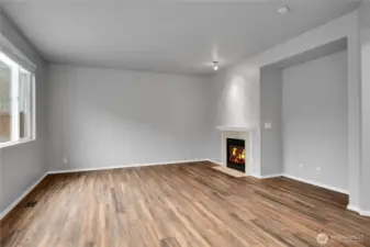 Family room with gas fireplace and LVP flooring opens to kitchen and eating area