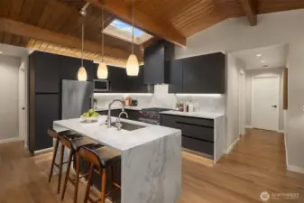 The east hallway brings you to the private primary suite. The west side leads to a powder room, full bathroom and two spacious additional bedrooms.