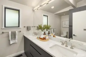 Primary bathroom with walk-in shower and two sinks.