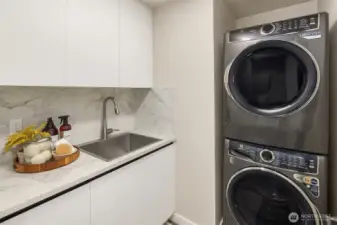 Laundry room with storage and a utility sink.